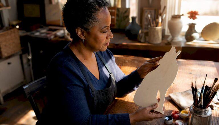 Woman inspecting Washington DC wood cutout in workshop