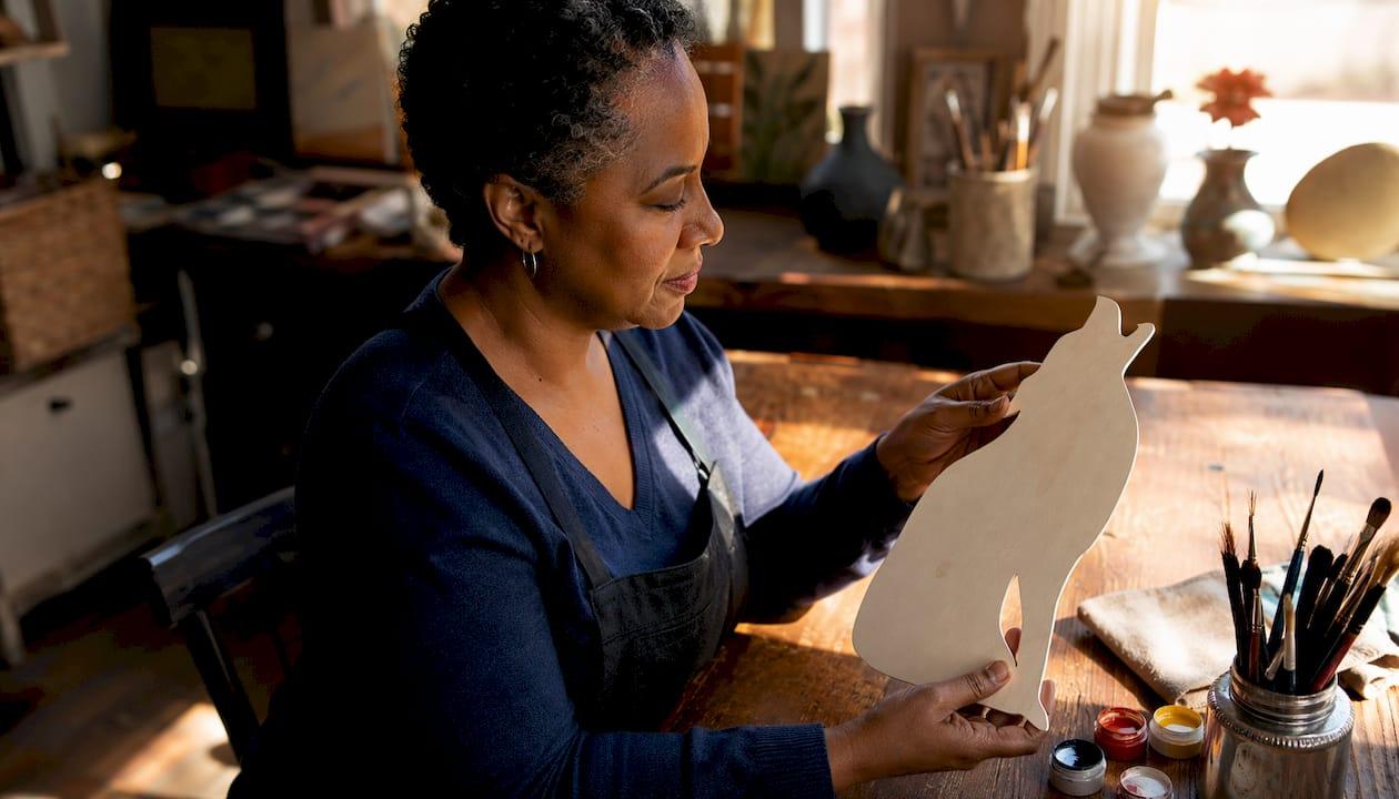 Woman inspecting Washington DC wood cutout in workshop