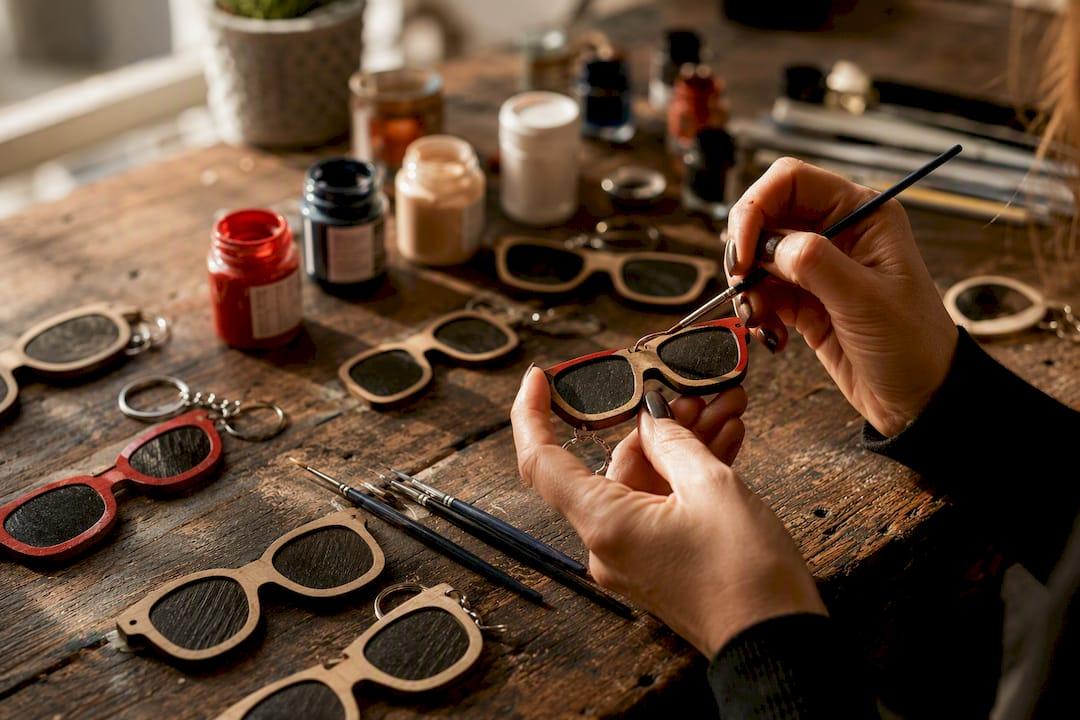 Hands painting wooden sunglasses keychains