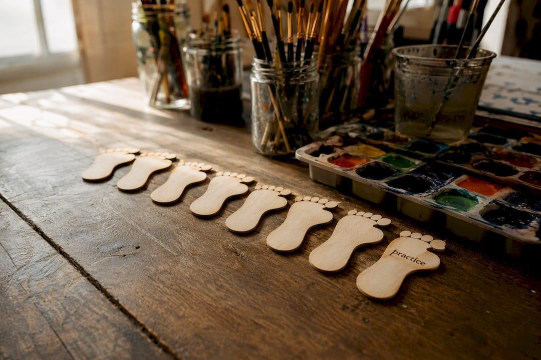 Practice wooden baby feet cutouts on craft table