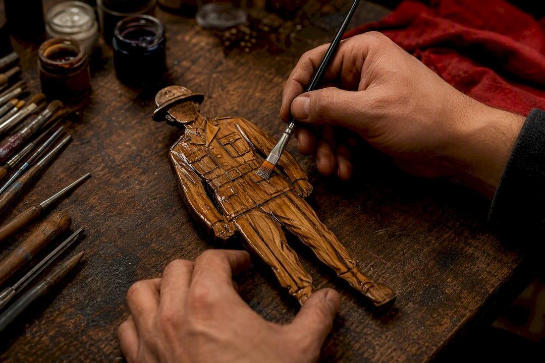 Hand applying resin to wooden cutout back