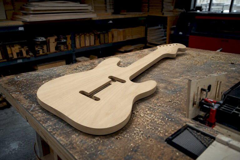 Large wooden guitar cutout sign on workbench