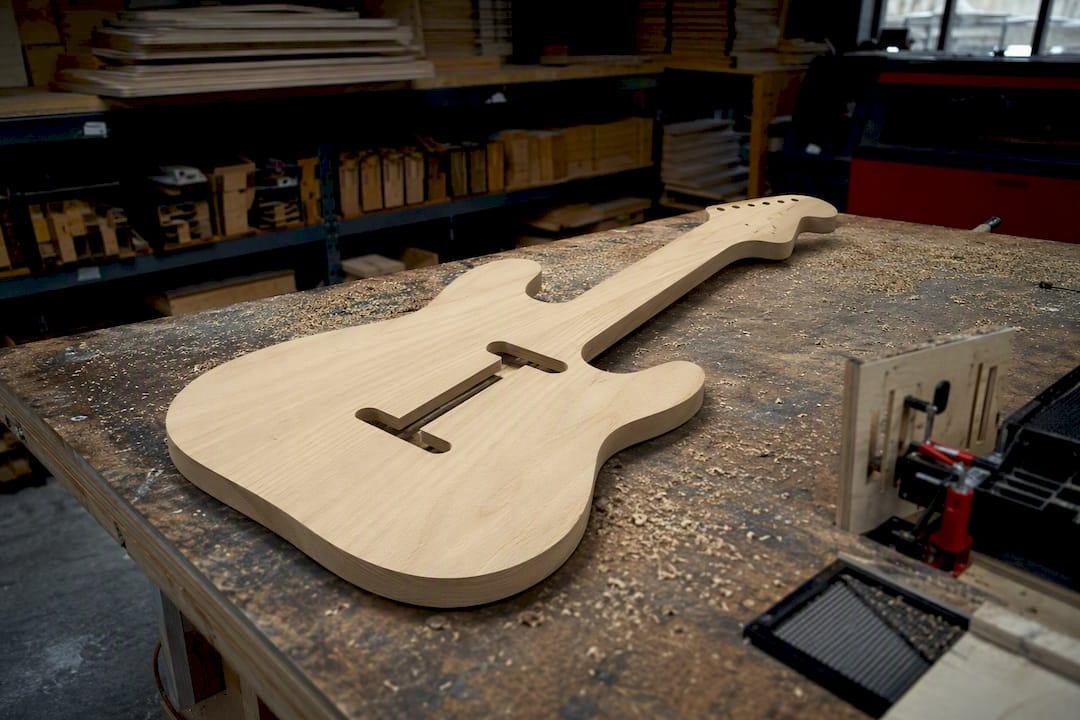 Large wooden guitar cutout sign on workbench