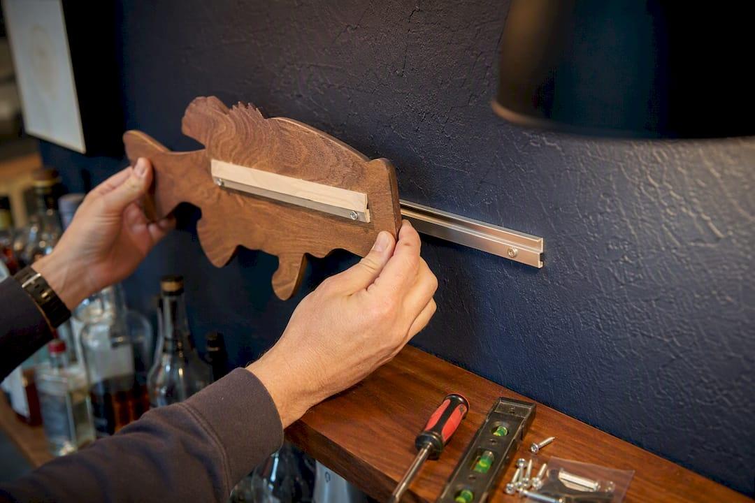 Close-up of hands mounting bass plaque with French cleat