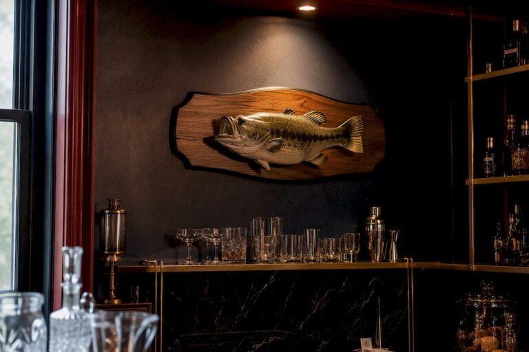 Jumping bass plaque mounted above home bar back bar