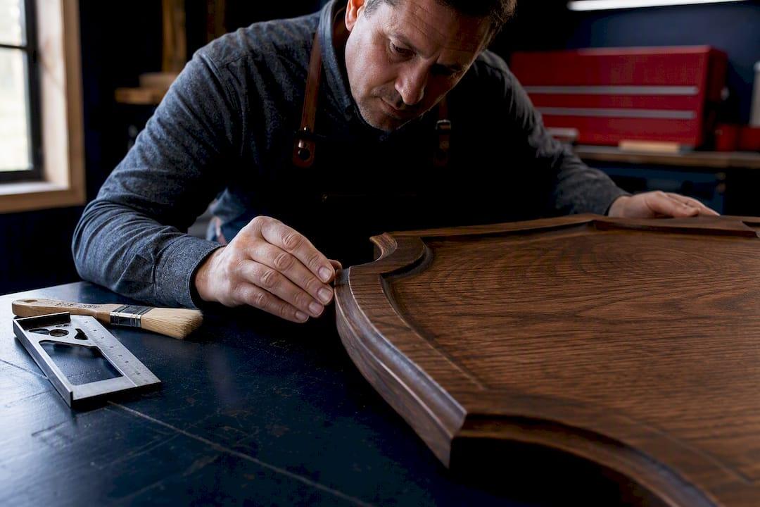 Maker inspecting a partially finished wood sign