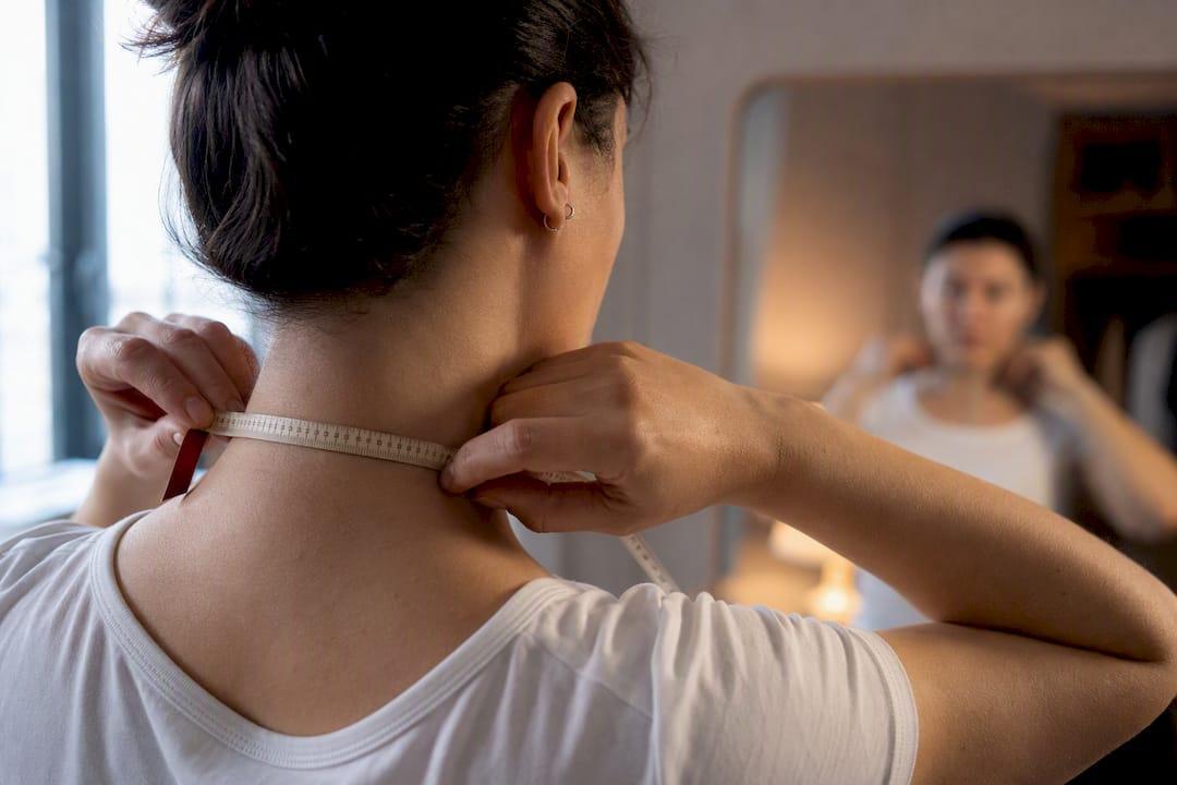 Persona midiendo una cadena alrededor del cuello
