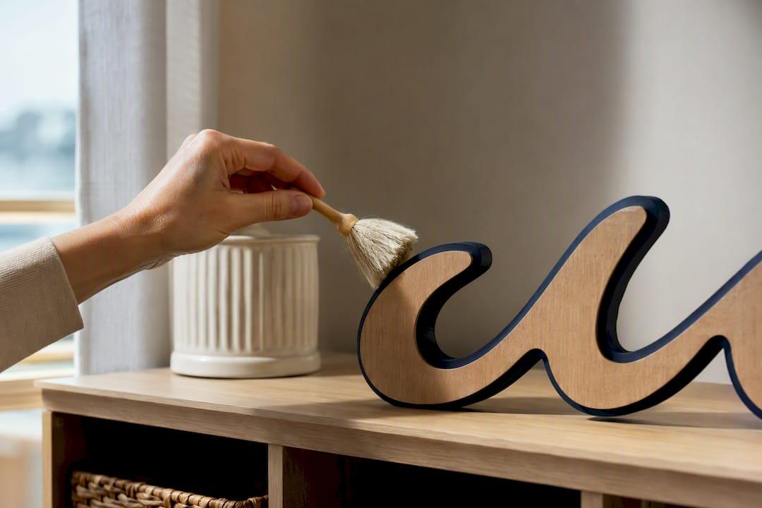 Hand dusting a painted wood sign edge