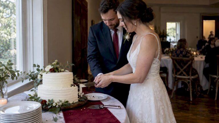 Couple cutting a wedding cake with serving set