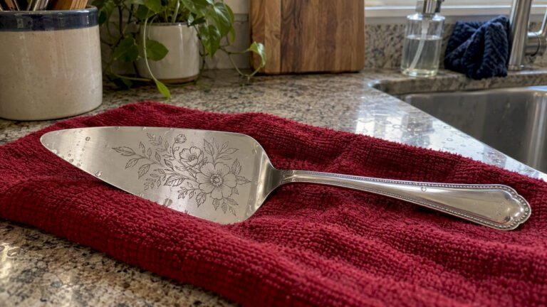 Laser-etched pie server drying on crimson cloth