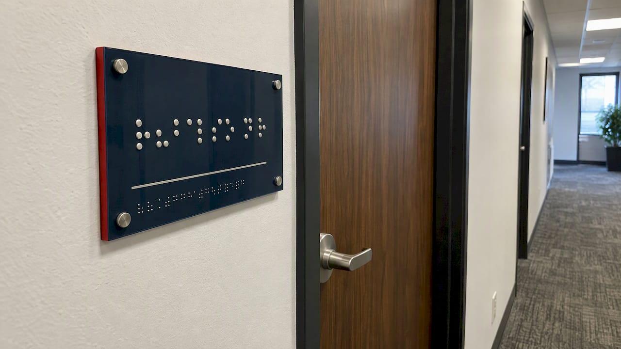 Tactile Braille sign beside an office door