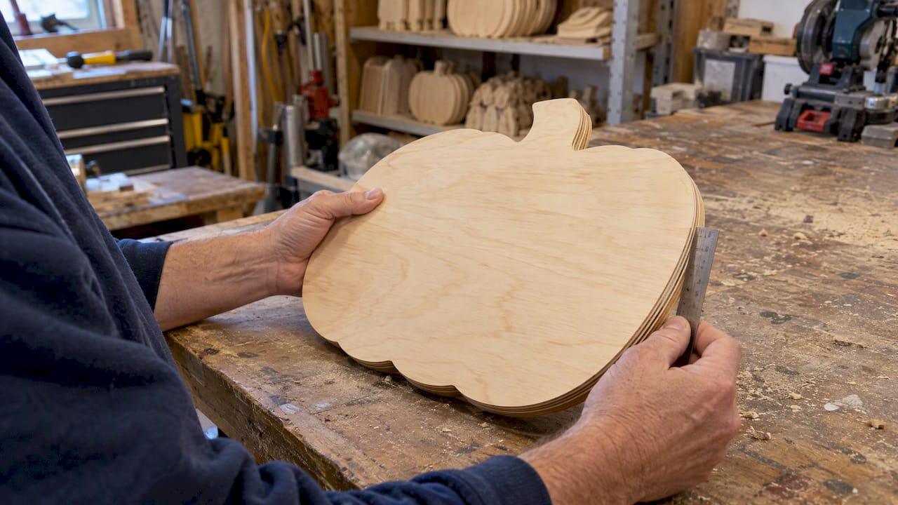 Unfinished plywood pumpkin blank under inspection