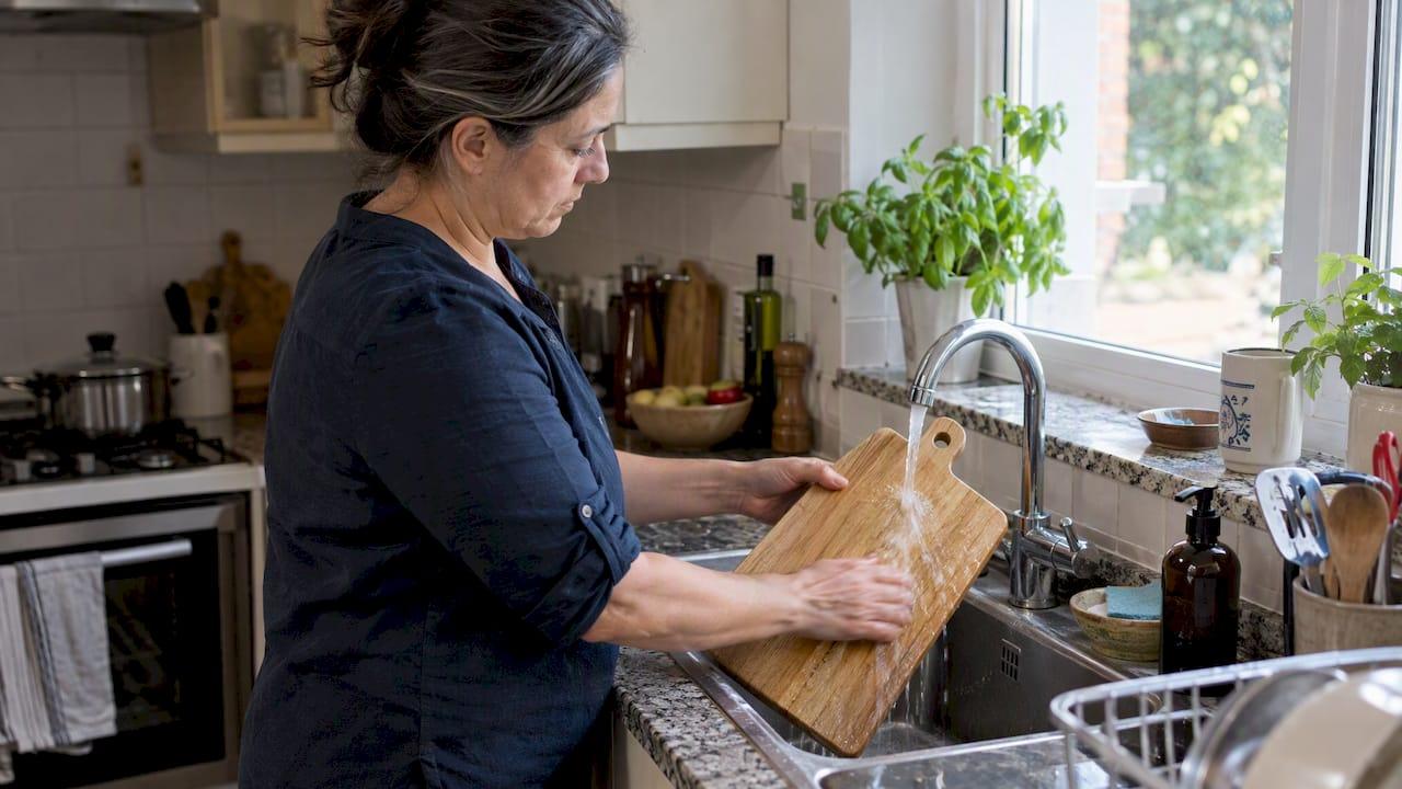 Mujer lavando una tabla de madera
